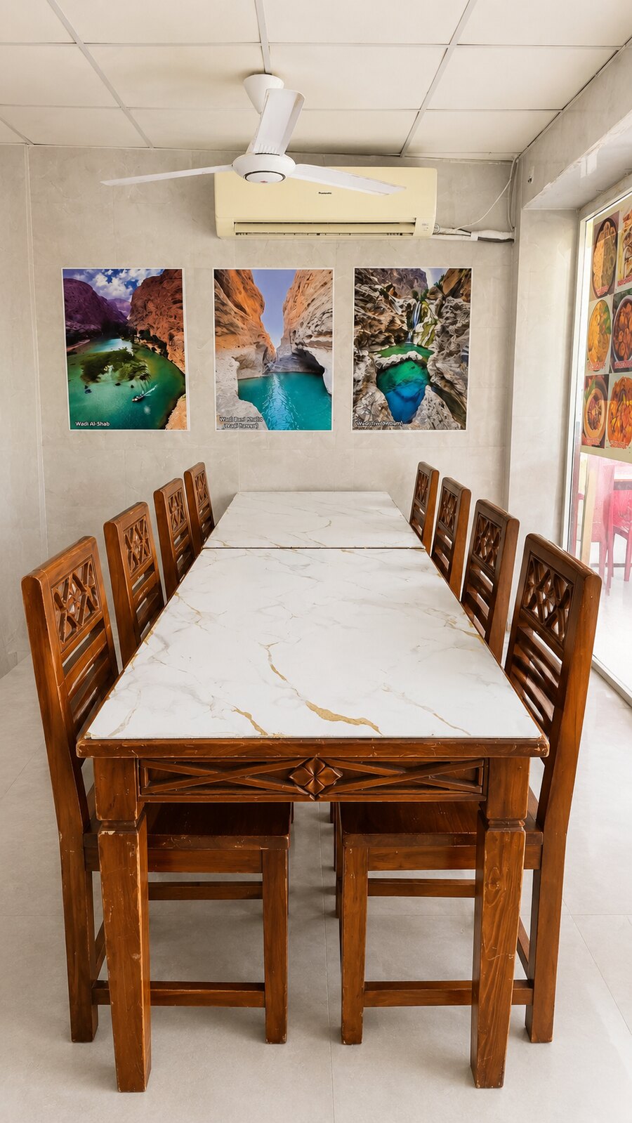 Indoor family dining room with a marble table and wooden chairs