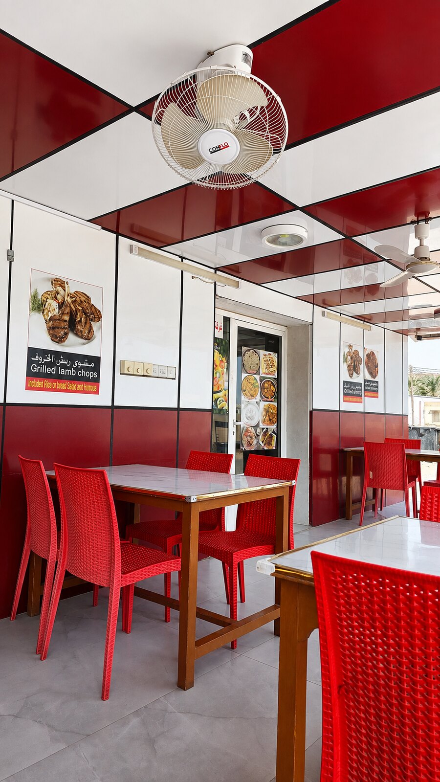 Covered red and white outdoor dining area with tables and chairs